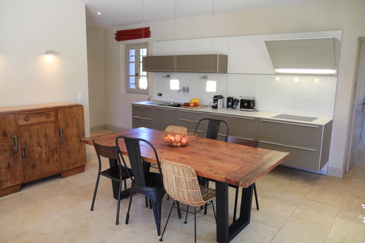 A kitchen with a wooden table and chairs