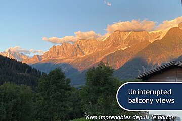 Golden sunset on majestic mountain peaks with green trees below. Text overlay: "Uninterrupted balcony views".