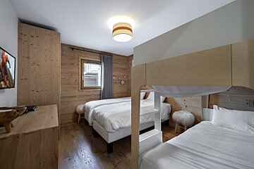 A bedroom with two beds and a bunk bed