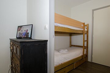A bunk bed in a bedroom next to a dresser