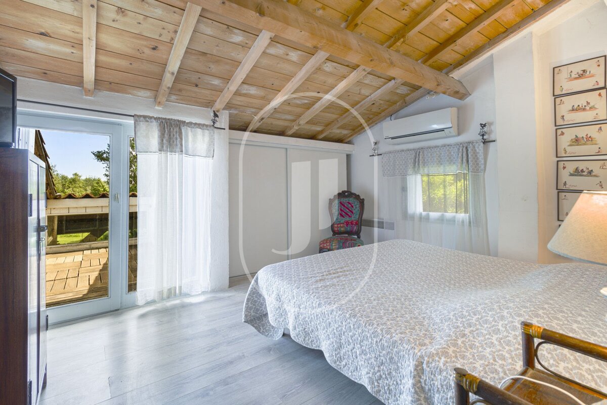 A bedroom with a wooden ceiling and a bed