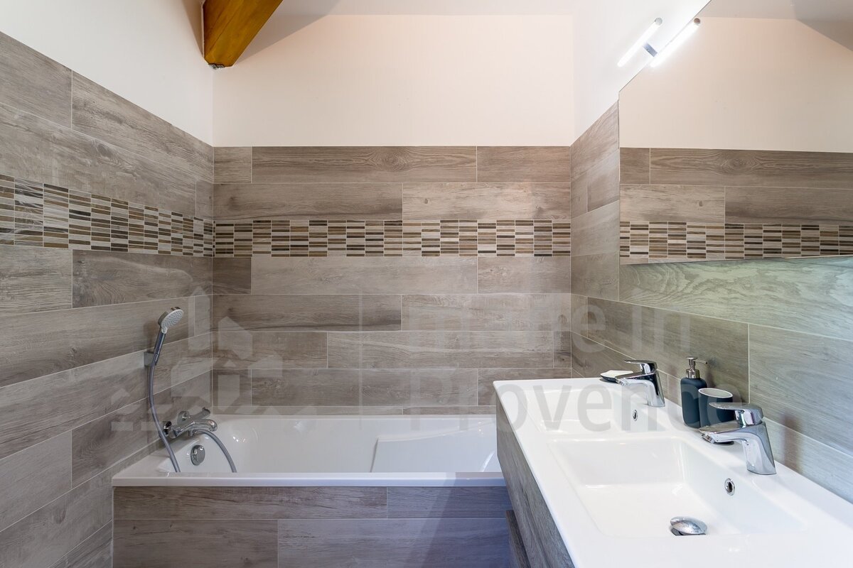 A bathroom with two sinks and a bathtub with the word over on the bottom