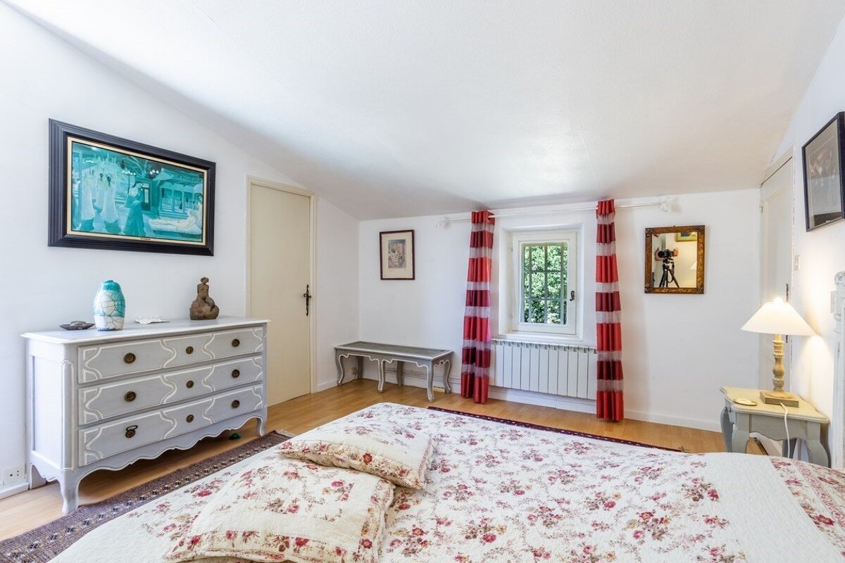 A bedroom with a bed a dresser and a mirror