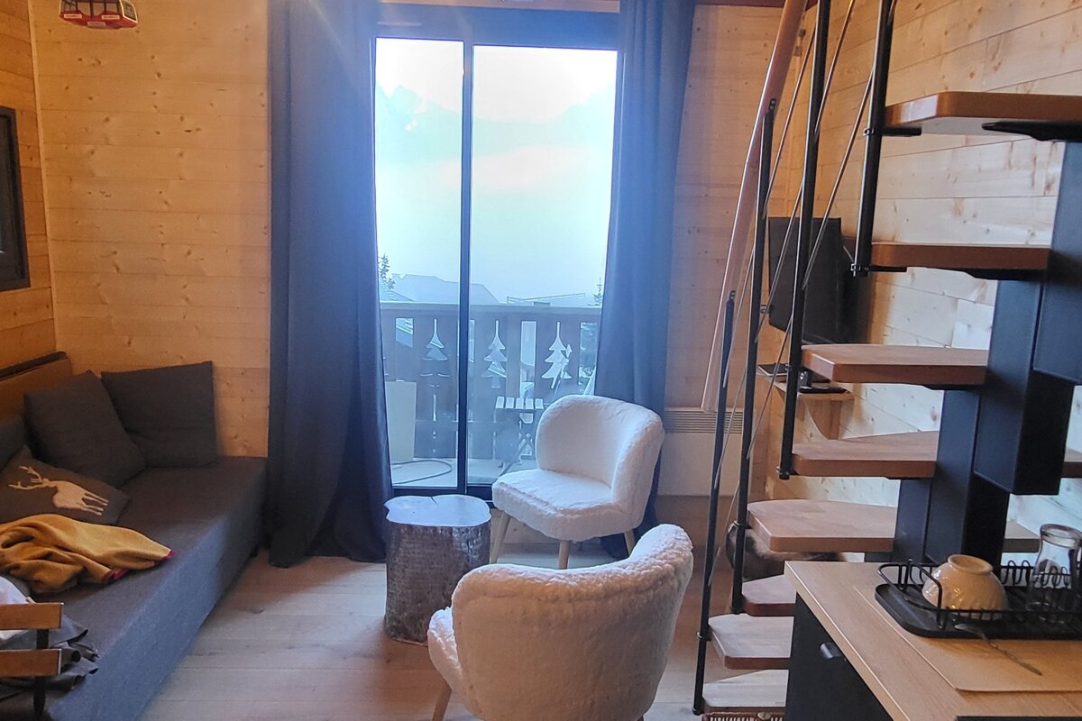 A living room with a couch a chair and a staircase