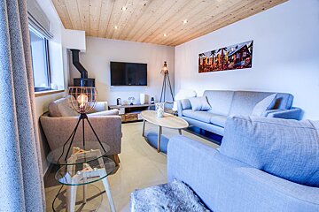 A living room with a couch a chair and a television