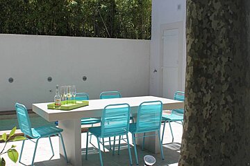 A table with blue chairs and a bottle of soda on it
