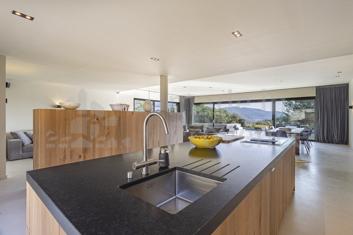 A kitchen with a black counter top and a stainless steel sink