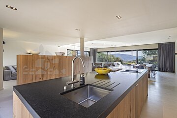 A kitchen with a black counter top and a stainless steel sink