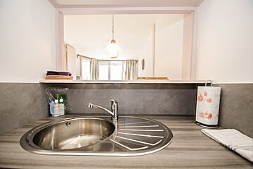 A stainless steel kitchen sink with a paper towel holder