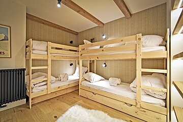 A room with bunk beds and a picture on the wall that says es