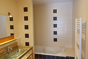 A bathroom with black and white tiles and a bathtub