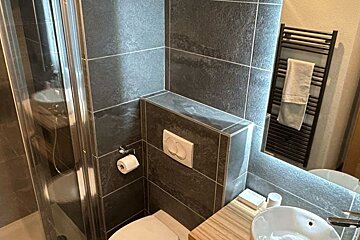 A bathroom with a toilet a sink and a mirror