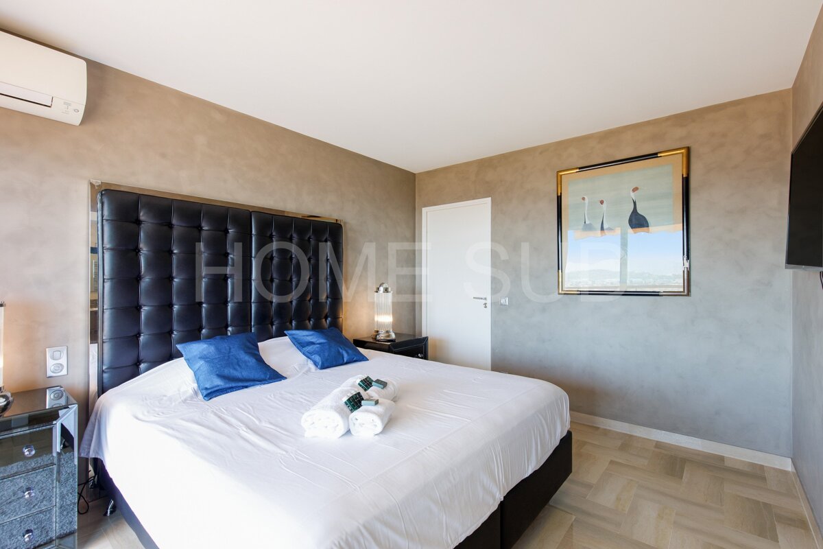 A bedroom with a large bed and a picture on the wall that says home su