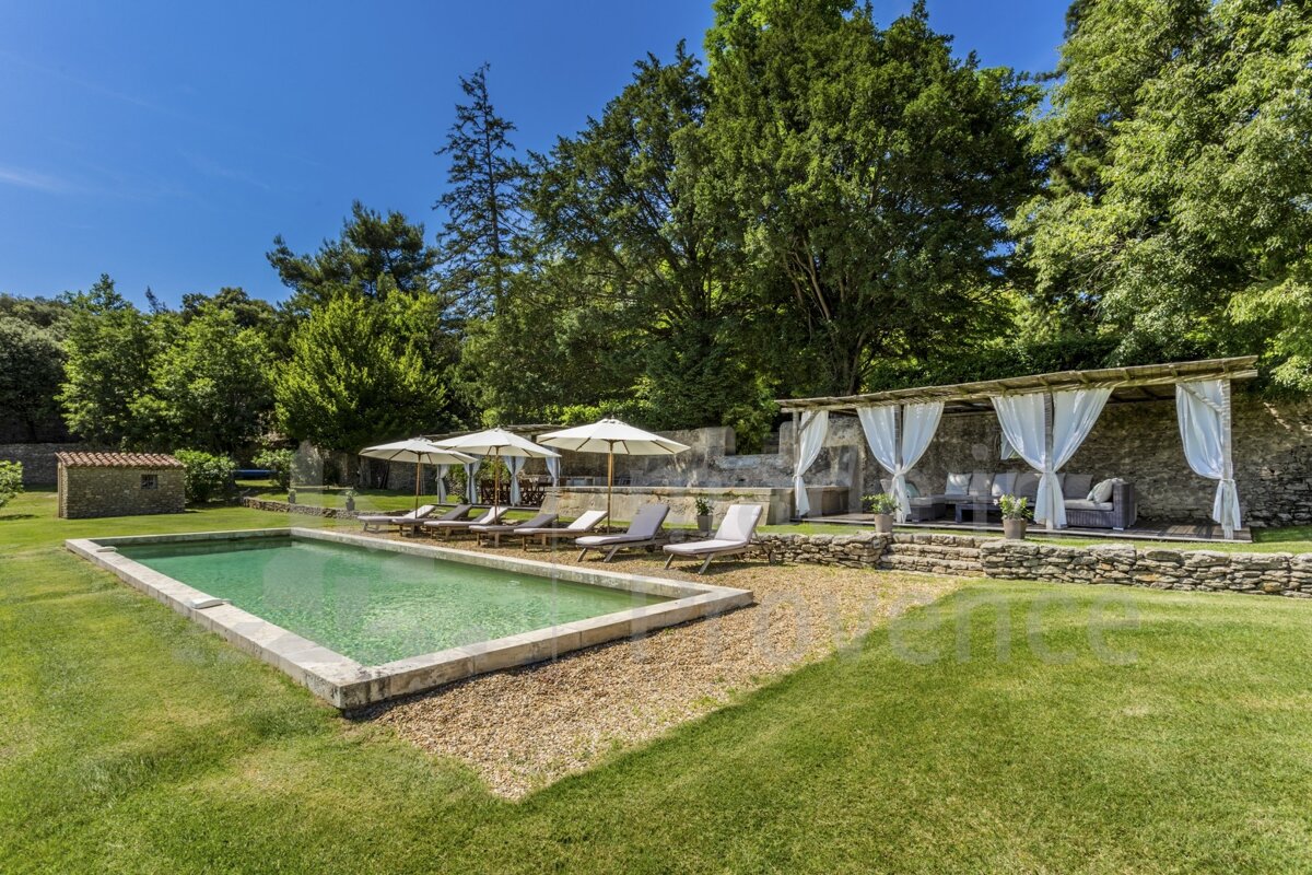 A large swimming pool surrounded by chairs and umbrellas