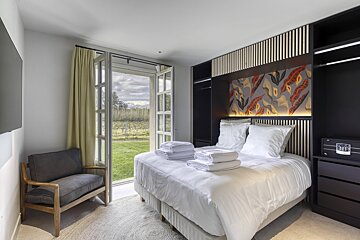 A hotel room with a bed and a chair