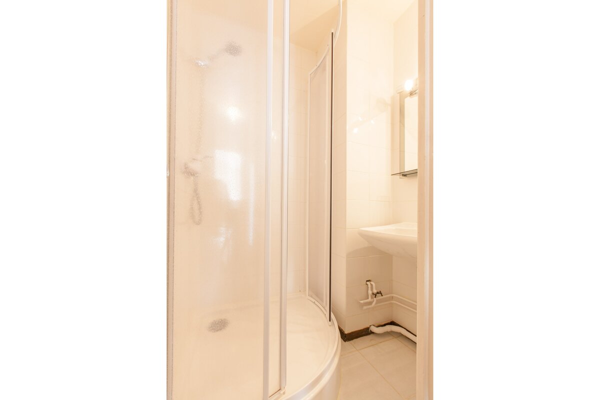 A bathroom with a sink and a shower stall