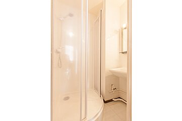 A bathroom with a sink and a shower stall