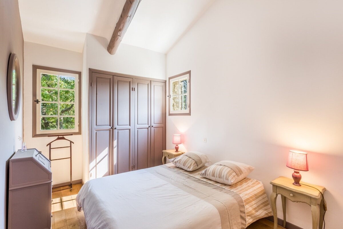 A bedroom with a bed and two lamps