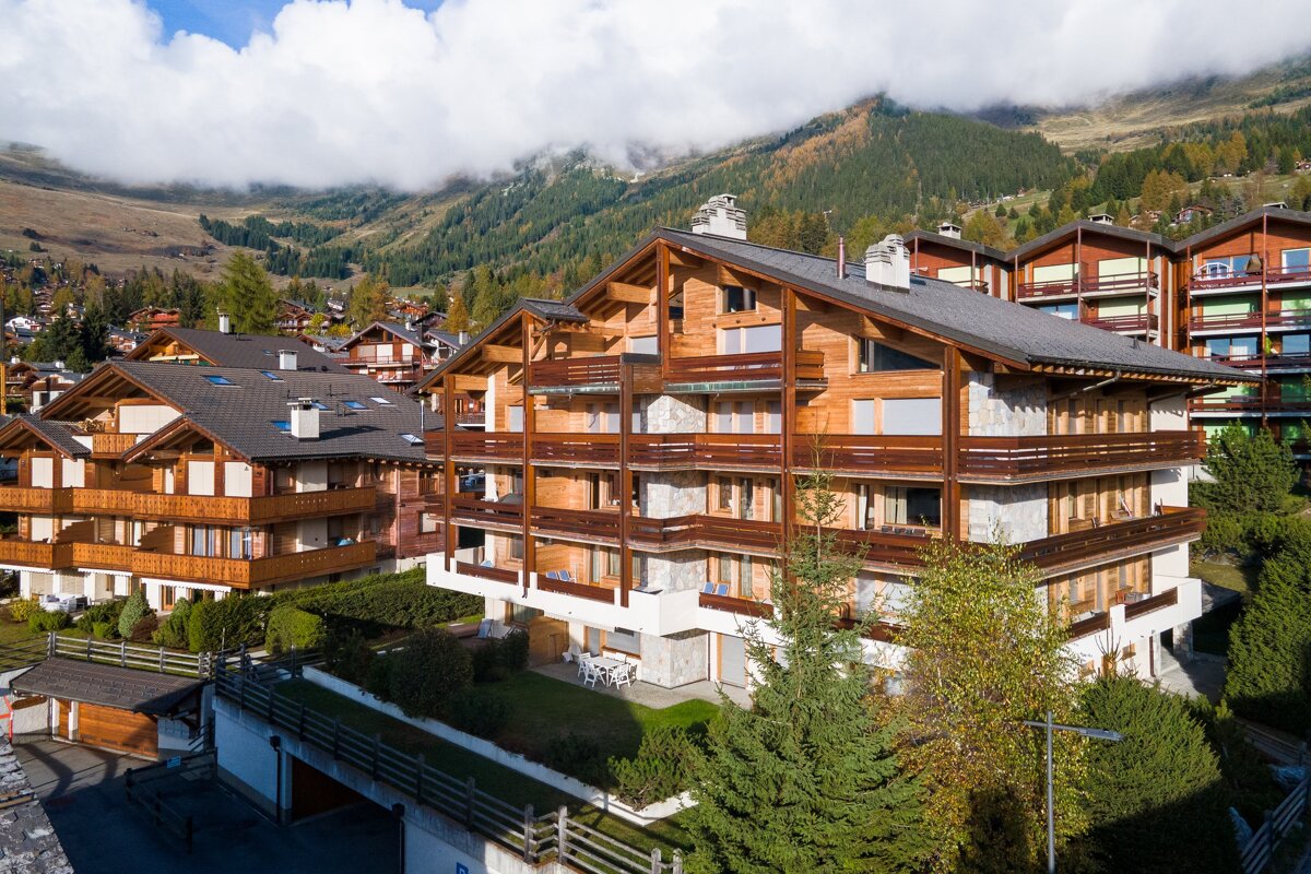 A large apartment building with a mountain in the background