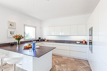 A kitchen with white cabinets and black counter tops