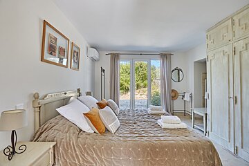 A bedroom with a king size bed and a mirror