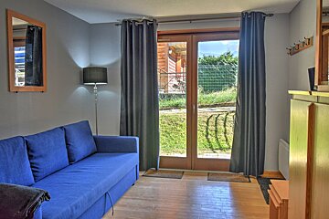 A living room with a blue couch and a mirror