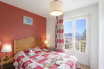 A bedroom with a bed and two lamps and a picture on the wall
