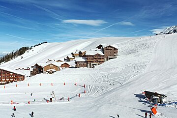 A snowy mountain with a hotel in the background