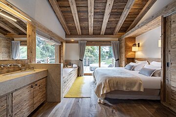 A bedroom with a large bed and a bathtub