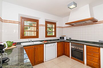 A kitchen with wooden cabinets and a white dishwasher