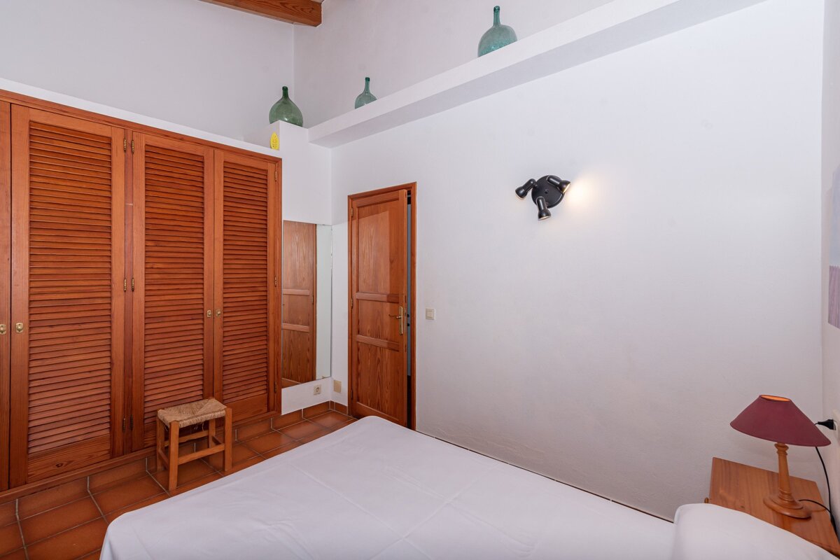 A bedroom with a bed and a wooden door