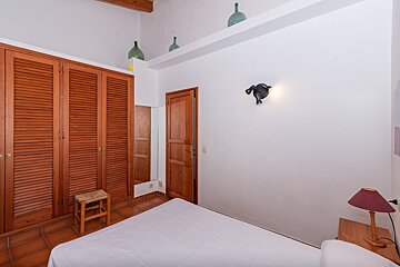 A bedroom with a bed and a wooden door