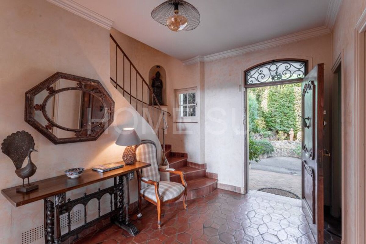 A hallway with stairs and a table that says home su