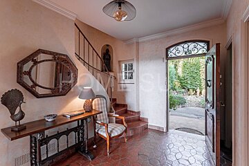 A hallway with stairs and a table that says home su