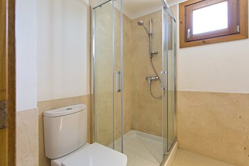 A bathroom with a toilet and a shower stall