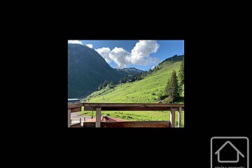 A picture of a mountain with a house in the corner