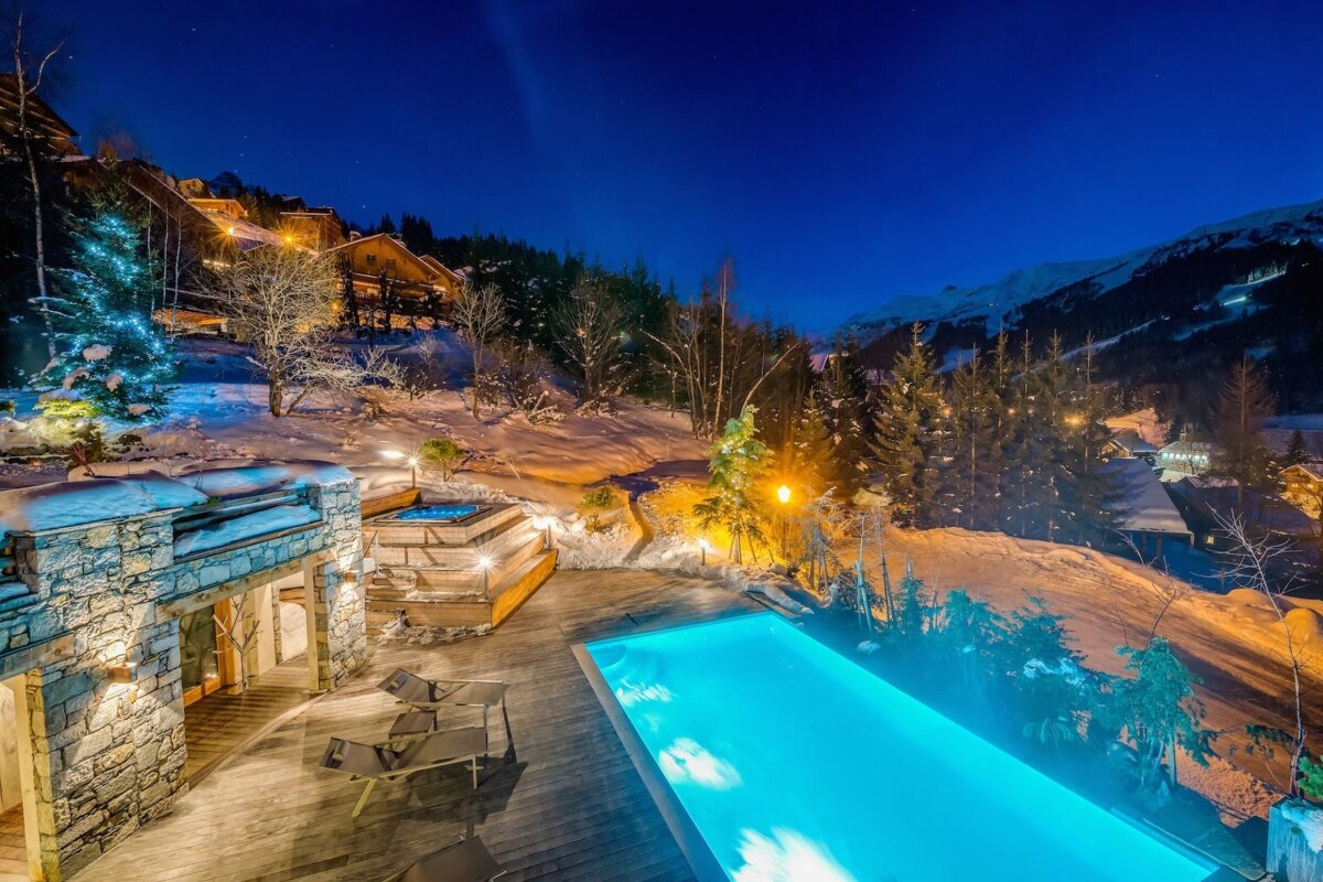 A large swimming pool is lit up at night