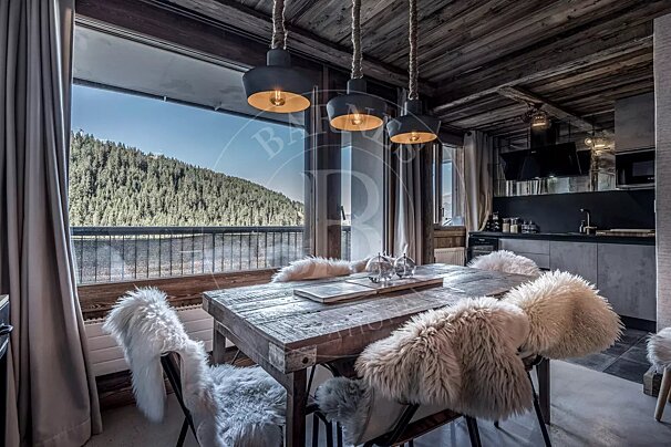 A dining room with a table and chairs and the letter b on the wall