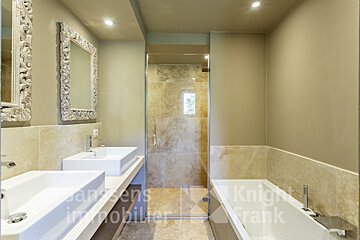 A bathroom with two sinks and a bathtub with knight frank written on the wall