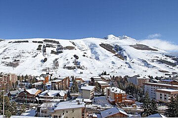 A snowy mountain is behind a small town