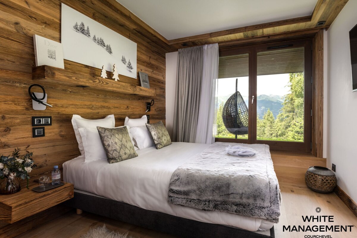 A bedroom with a rental designer logo on the corner