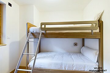 A bedroom with a rental designer logo on the wall
