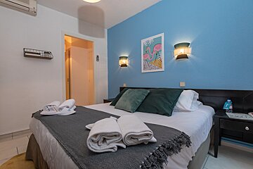 A bedroom with a picture of a flamingo on the wall