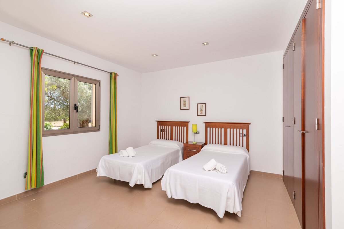 A bedroom with two twin beds and a window