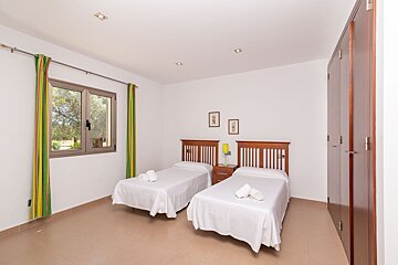 A bedroom with two twin beds and a window