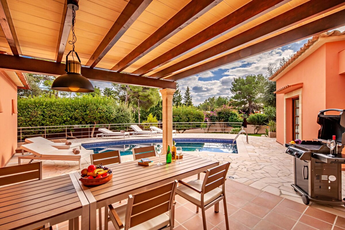 A patio with a table and chairs and a grill