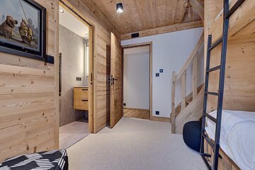 A wooden hallway with bunk beds and a ladder