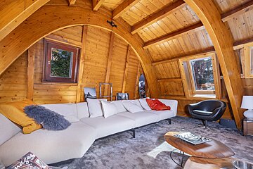 A living room with wooden beams and a stone floor