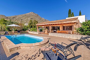 A house with a large swimming pool in front of it