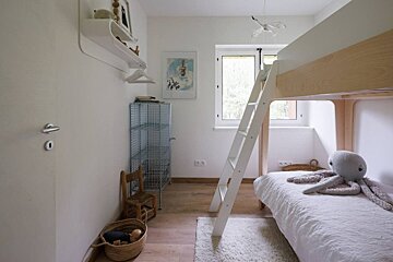 A bedroom with a bunk bed and a ladder